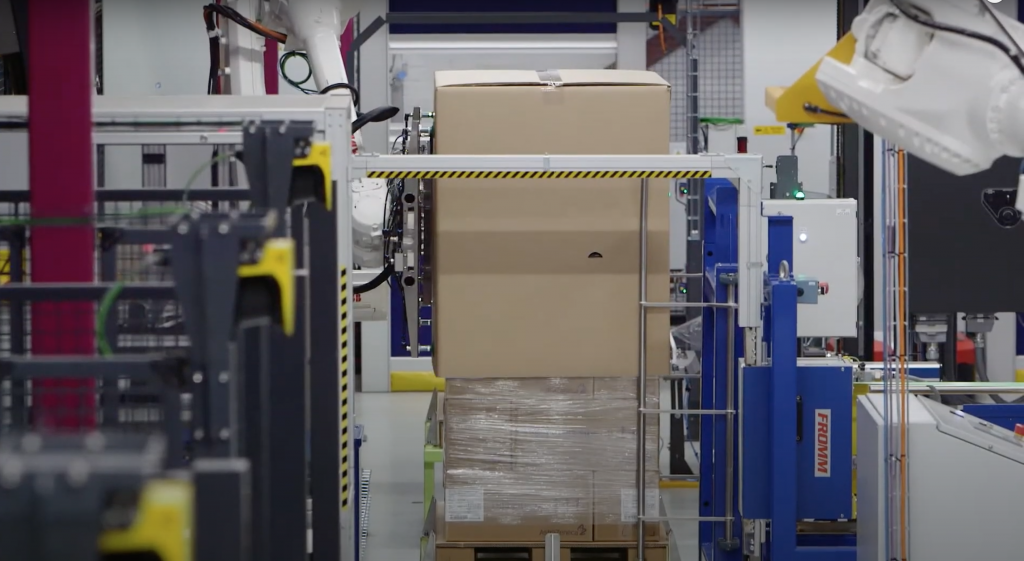 Nasadenie kartónového obalu priemyselným robotom